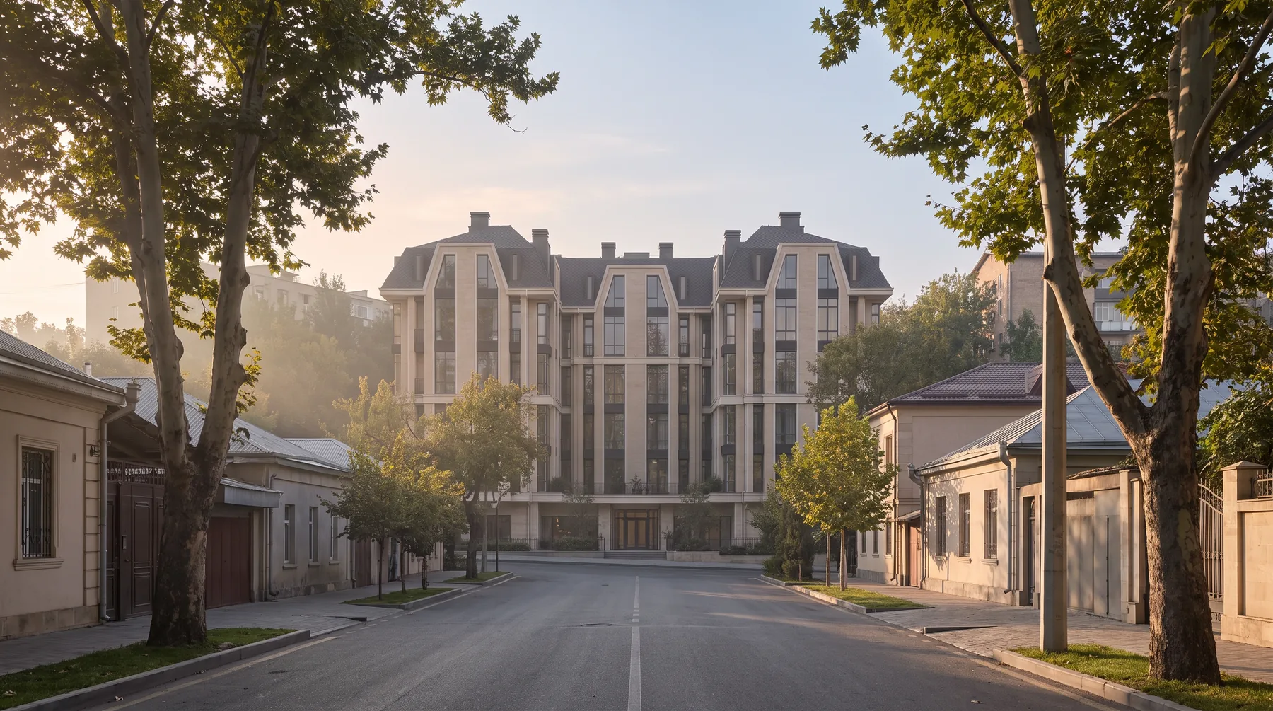 Дом с улицы: три корпуса под одной кровлей, ряд деревьев, тротуар.